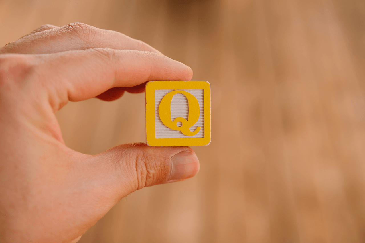 Gelber Buchstabenblock Q in Hand